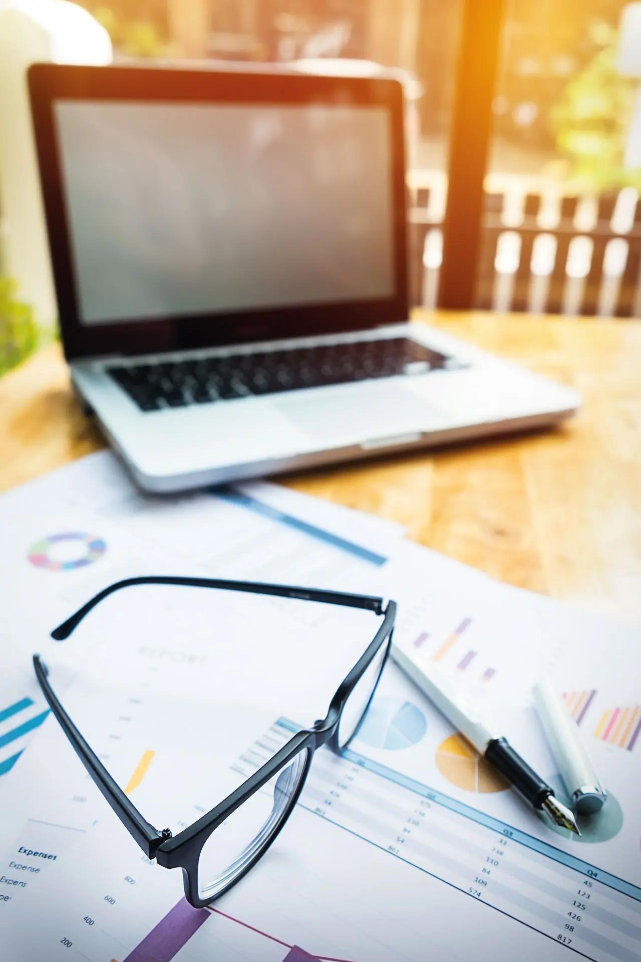 Oficina de trabajo con ordenador portátil, lentes y documentos sobre la mesa | Rentar mi Propiedad | Maloka - Florida Real Estate Broker | Creemos en la generación de riqueza a través de la propiedad de vivienda